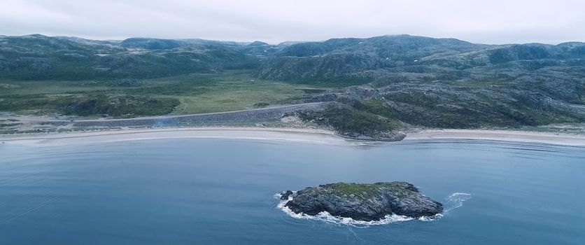 A beach with rocky hills. Tundra in the Russian north.