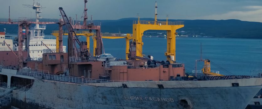 Auxiliary cargo ship in the industrial port.