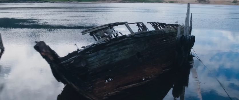 Rotten old wooden boat on the shore.