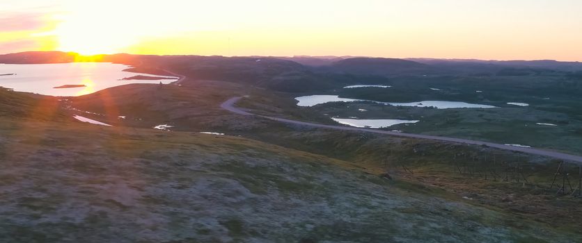 Sunset in the tundra among the hills. Hilly tundra.