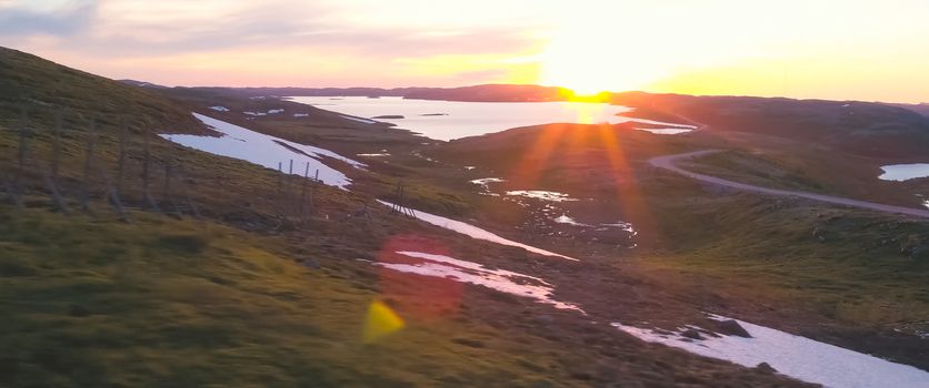 Sunset in the tundra among the hills. Hilly tundra.