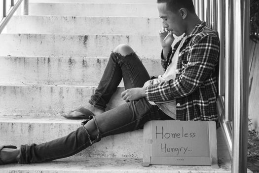 Unhappy homeless man sitting on overpass