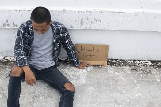 Unhappy homeless man sitting on overpass