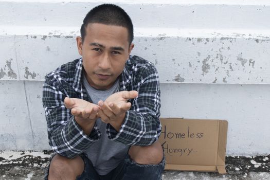 Unhappy homeless man sitting on overpass