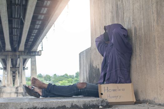 Unhappy homeless man under the bridge