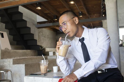 Asian business man drinking ice coffee in cafe