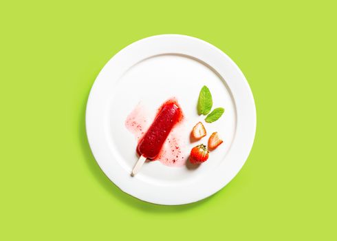 Delicious strawberry popsicles on light background