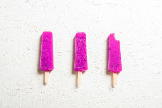 Delicious strawberry popsicles on light background