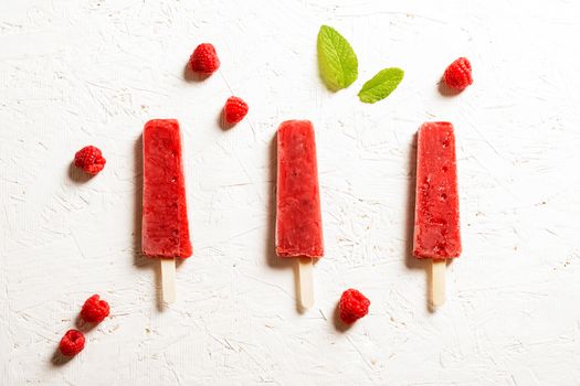 Delicious strawberry popsicles on light background