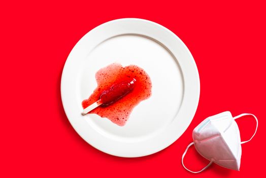 Delicious defrosted strawberry popsicles and medical mask over red background