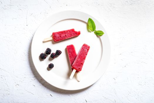 Delicious strawberry popsicles on light background