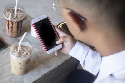 Closeup view of male hands touching mobile phone in cafe