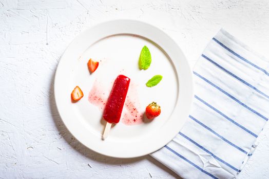Delicious strawberry popsicles on light background