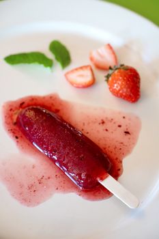 Delicious strawberry popsicle on light background