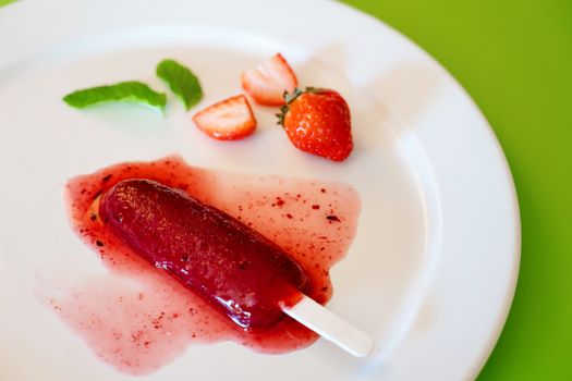 Delicious strawberry popsicles on light background