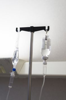 Dark image of a IV drip bags in a hospital room.