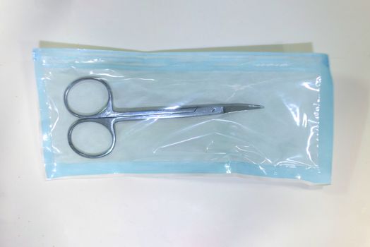 Medical scissors inside a sterilized blister ready for use it.