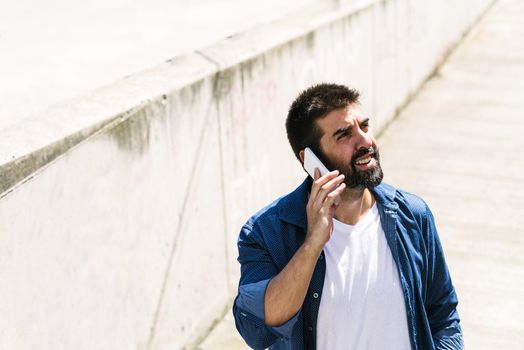 Portrait of a bearded man using his mobile.