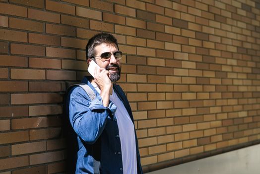 Portrait of a bearded man using his mobile.