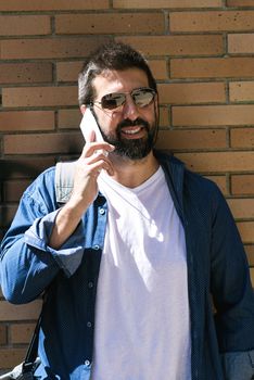 Portrait of a bearded man using his mobile.