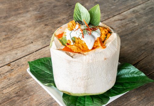 Steamed coconut curry on wooden table at restaurant