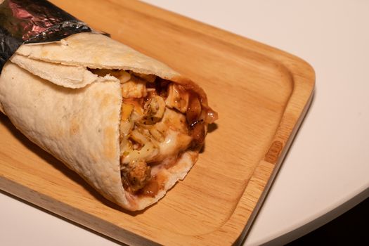 Chicken Kebab roll on wooden plate