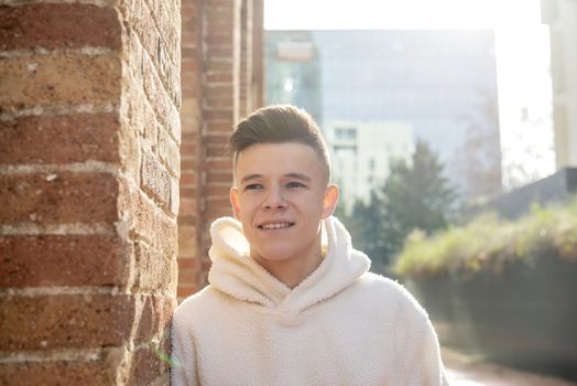 Portrait of young male with hands on pocket leaning on wall outdoors