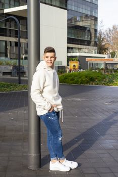 Portrait of young male with hands on pocket leaning on wall outdoors