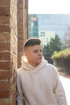 Portrait of young male with hands on pocket leaning on wall outdoors