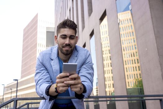 Portrait of Handsome young man smiling when he is using his mobile phone