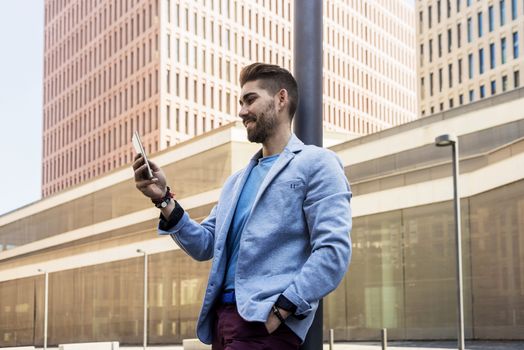 Portrait of Handsome young man smiling when he is using his mobile phone