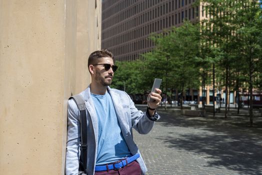 Portrait of Handsome young man smiling when he is using his mobile phone