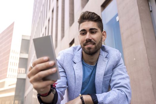 Portrait of Handsome young man smiling when he is using his mobile phone