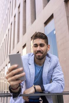 Portrait of Handsome young man smiling when he is using his mobile phone