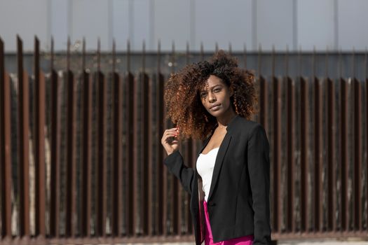 Portrait of a beautiful afro american woman standing in the street in a sunny day