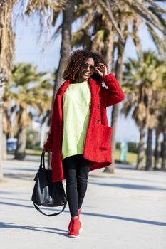 Portrait of a beautiful afro american woman standing in the street in a sunny day