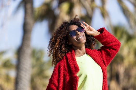 Portrait of a beautiful afro american woman standing in the street in a sunny day