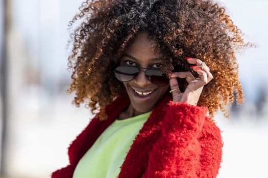 Portrait of a beautiful afro american woman standing in the street in a sunny day