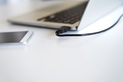 Close up of communicators device on desk, mobile phone and laptop