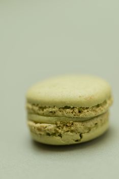 Vintage pastel colored French macaroons or macarons on green background