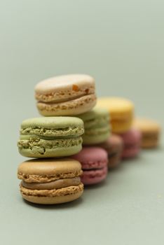 Vintage pastel colored French macaroons or macarons on green background