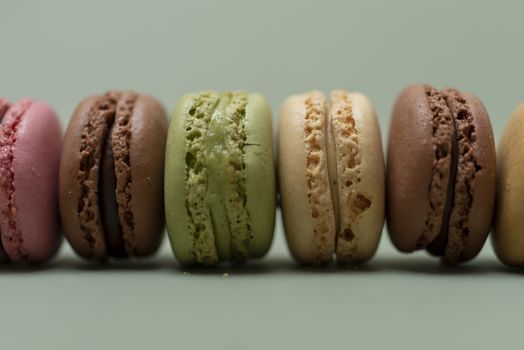 Vintage pastel colored French macaroons or macarons on green background