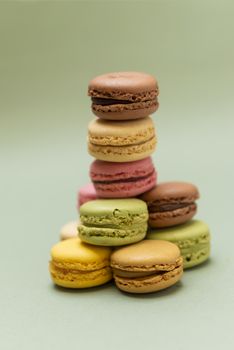 Vintage pastel colored French macaroons or macarons on green background