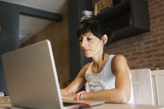 Woman with laptop working at home.