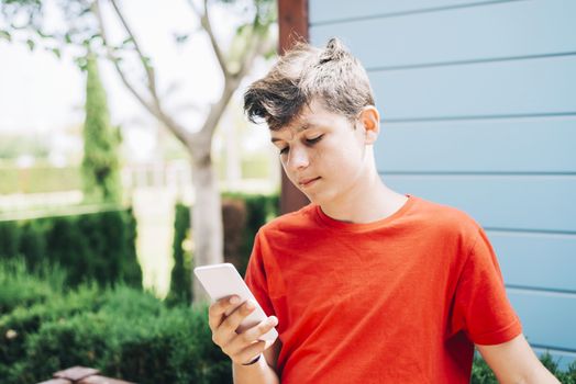 Profile of a happy guy texting on a smart phone