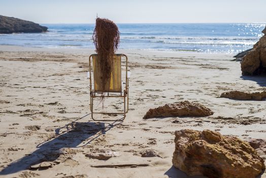 Side view of Trunk doll on beach chair simulating a person sunbathing