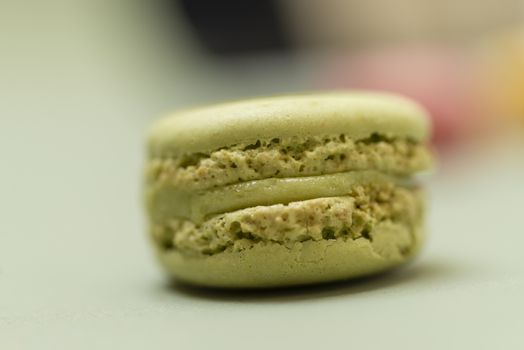 Colored tasty  macaroons over a green background.