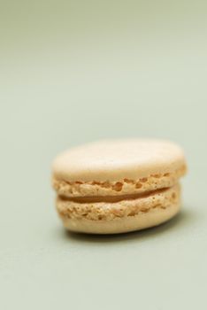 Colored tasty  macaroons over a green background.