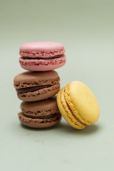 Colored tasty  macaroons over a green background.