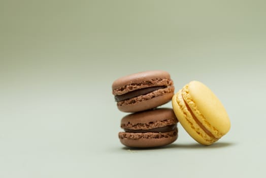 Colored tasty  macaroons over a green background.